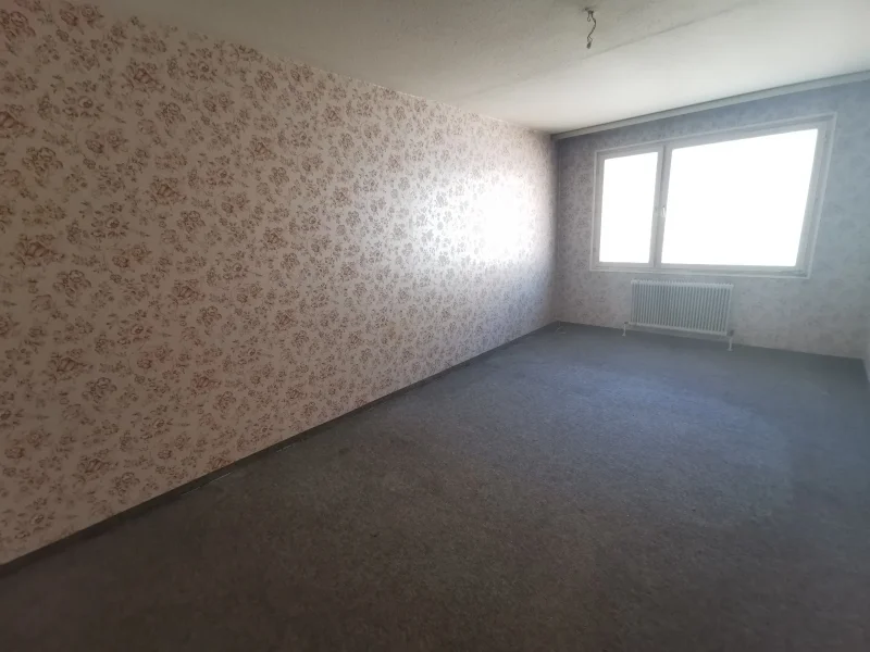 Altes, leerstehendes Zimmer mit vergilbter Blumentapete und ranzigen Teppichboden